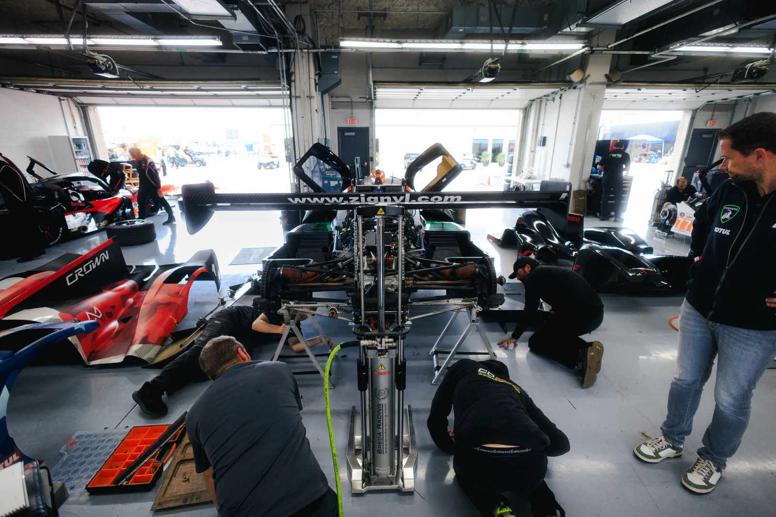 Forbush Performance crew working together around the exposed rear of the Duqueine in the COTA garage