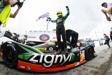 Jules Caranta celebrating with a checkered flag on the No. 18 Duqueine at Road Atlanta