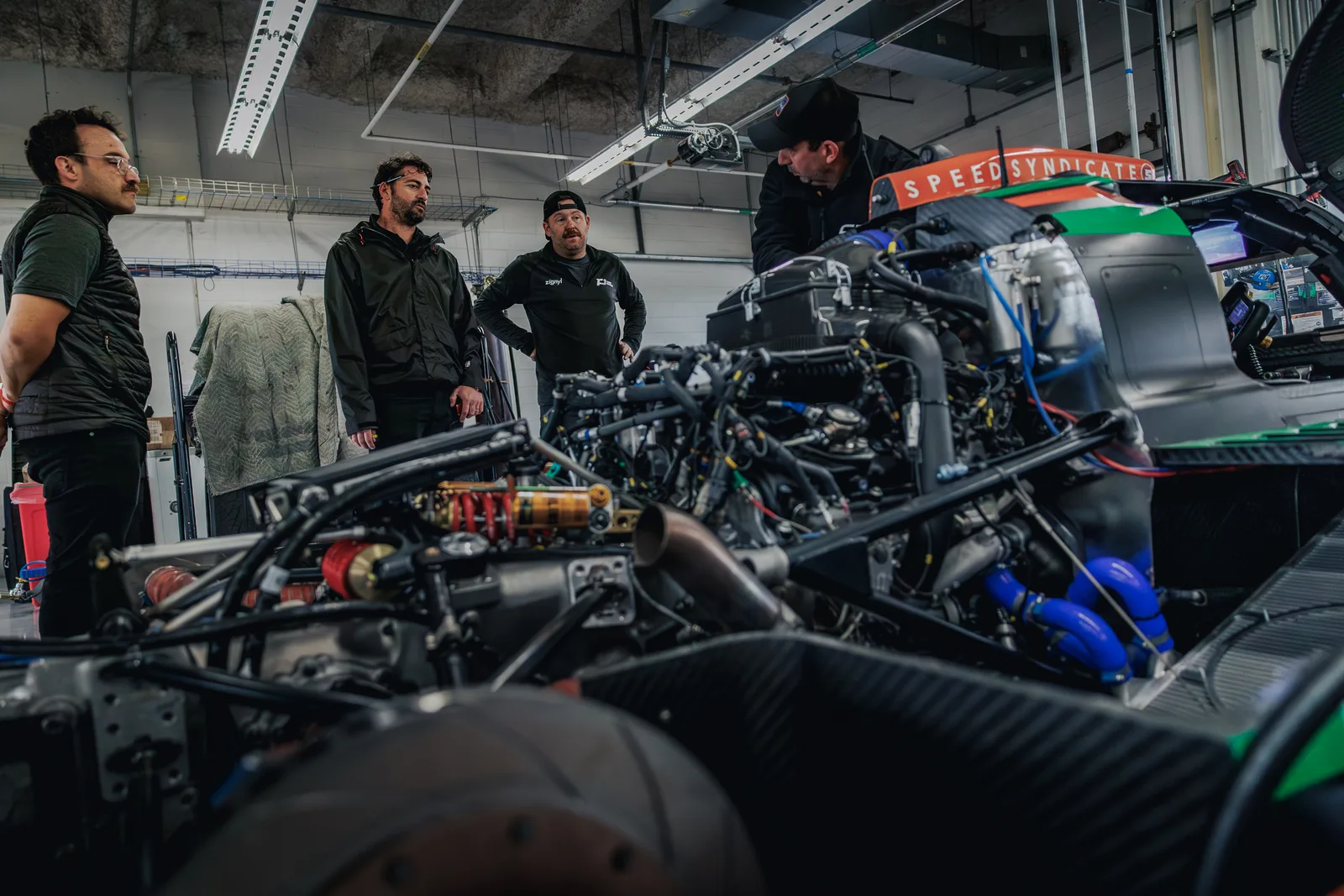 The crew gathered around the car in the COTA garage