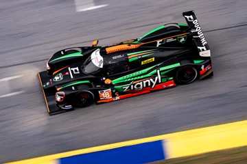 Elevated view of the No. 18 Duqueine racing beside blue-and-yellow curbing at Road Atlanta.