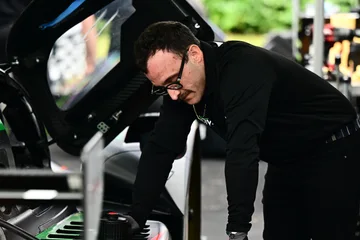 A Forbush Performance mechanic works beneath open bodywork in the Road Atlanta paddock.