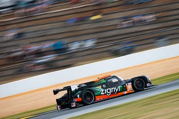 The No. 18 Duqueine races past the Road Atlanta grandstands in a panning photograph.