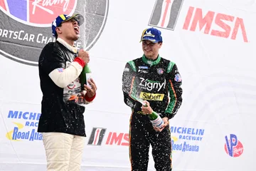 Drivers celebrate with champagne spray on the Road Atlanta podium.