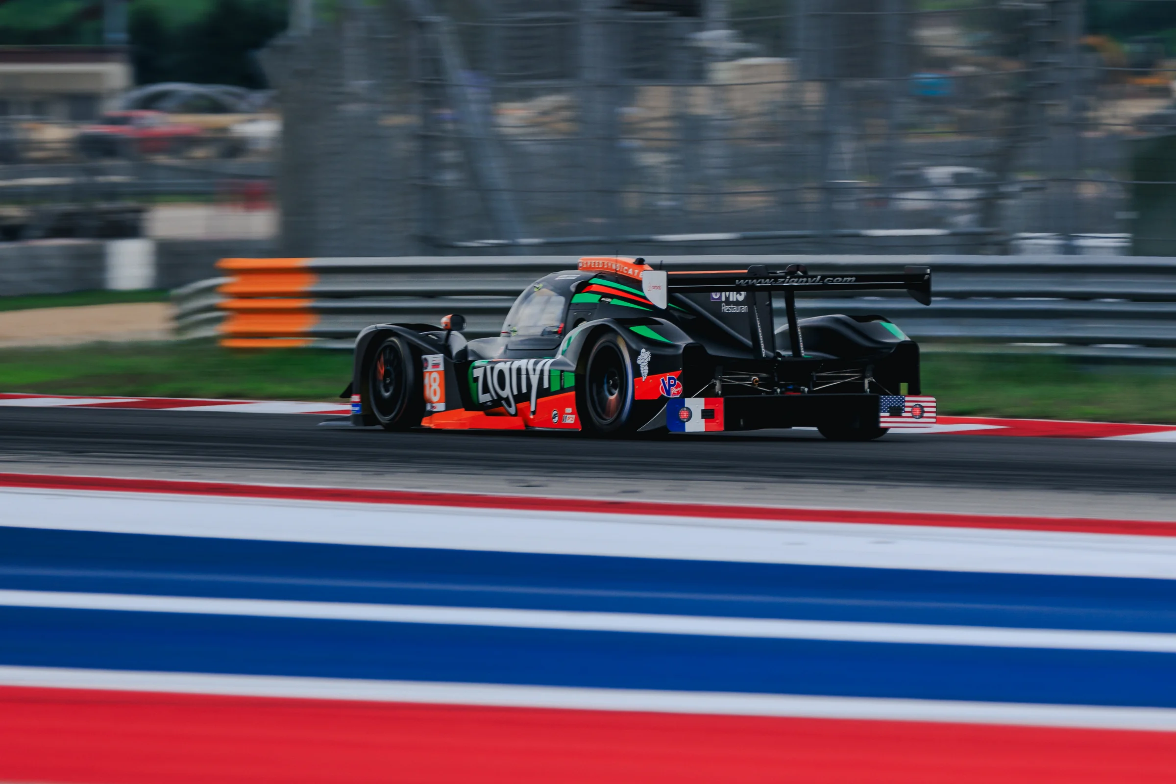 Rear three-quarter view of the No. 18 Duqueine at COTA, with French and American flags on the rear