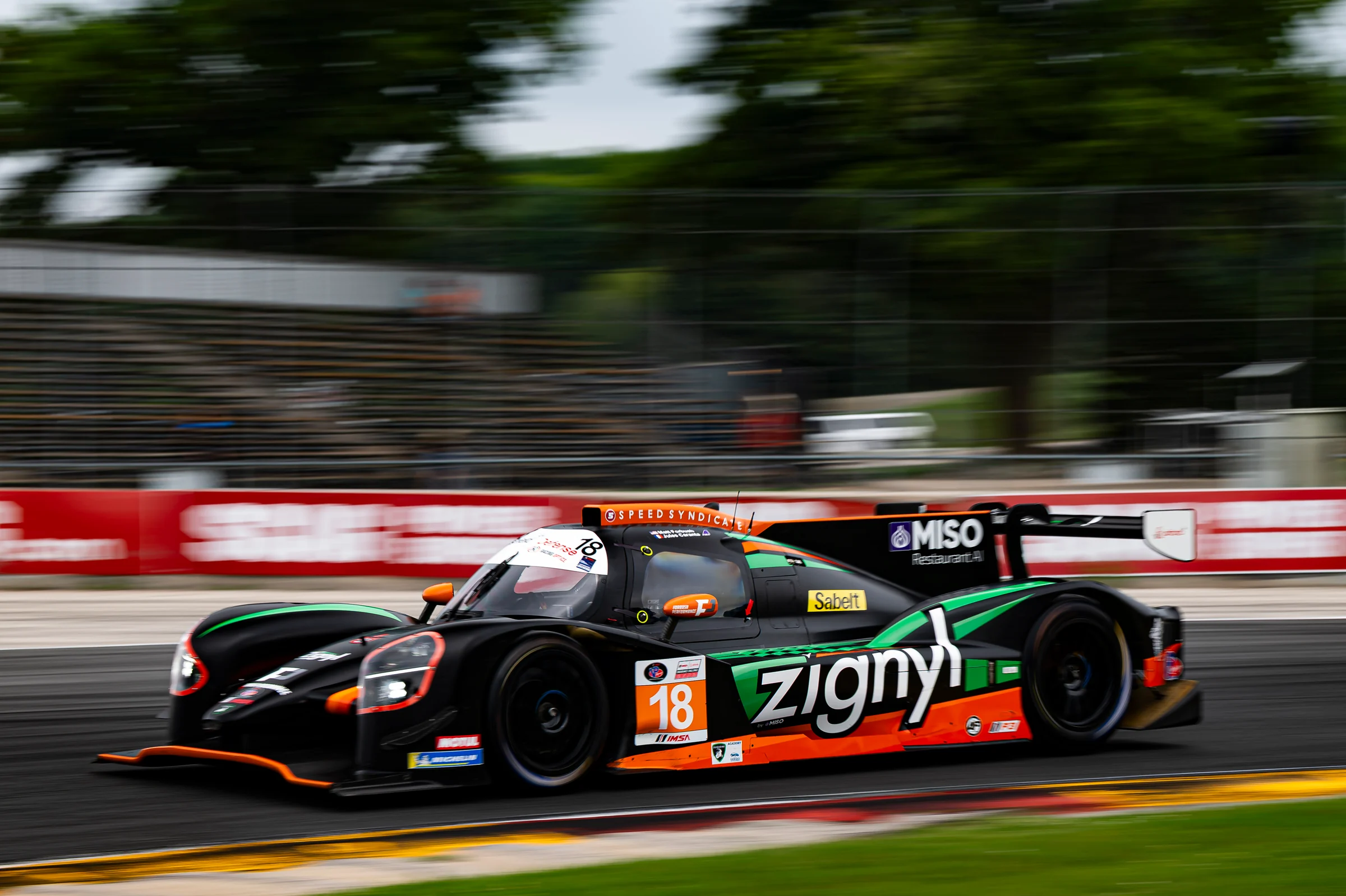 The No. 18 Duqueine carrying speed through Road America, with the Zignyl livery sharp against blurred trees